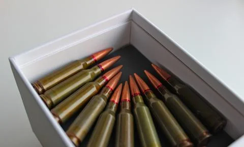 Machine gun bullets lined up with heads to heads in white case Stock Photos