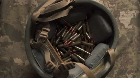Machine gun bullets stuffed into a tactical combat helmet. Stock Footage 205259428