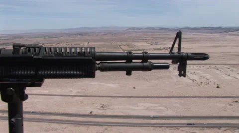 Machine gun on gunship helicopter while in flight over desert Stock Footage 45521690