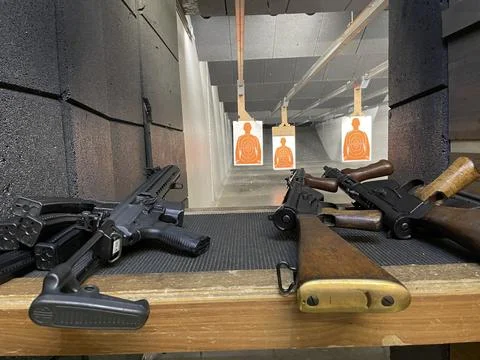 Machine Guns On A Table At A Shooting Range With Paper Targets Foto stock