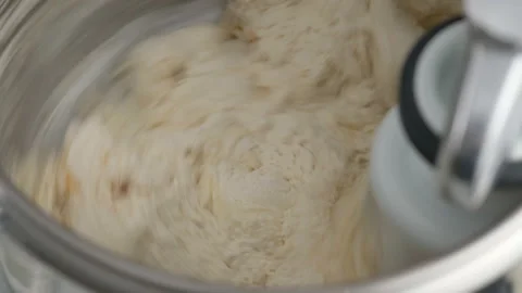 Machine kneading dough for donuts. Preparation of raw dough from butter, flour Stock Footage 146864227