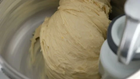 Machine kneading dough for donuts. Preparation of raw dough from butter, flour Stock Footage 146864306