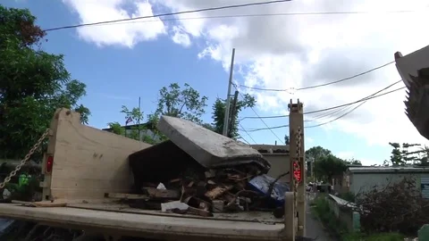 Machine loading debris left by Hurricane Maria onto truck in Puerto Rico Vidéo 82790288