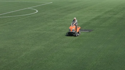 Machine for maintenance of artificial turf. lawn rides on a football field. Stock Footage 108628868