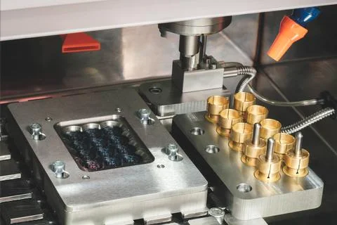 Machine is making a metal object with a lot of holes in it. The holes are bei Foto stock