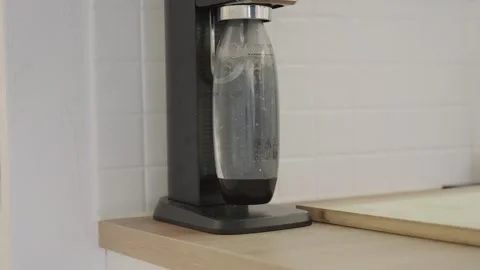 Machine for making sparkling water at home carbonating a bottle of fresh cold Stock Footage 335206936