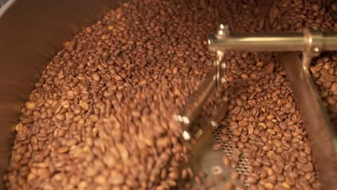 Machine mixes freshly roasted coffee beans in a roaster, close up Stock Footage 170696970