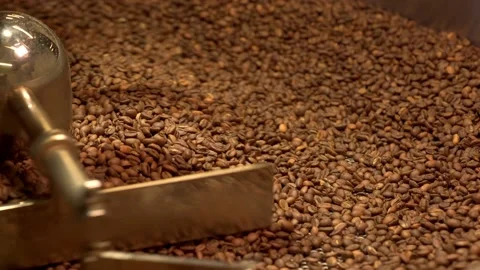 Machine mixes freshly roasted coffee beans in a roaster, close up Stock Footage 170697499
