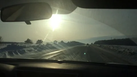 Machine moving on winter snow-covered road, with views of the sunset and the Stock Footage 74196211