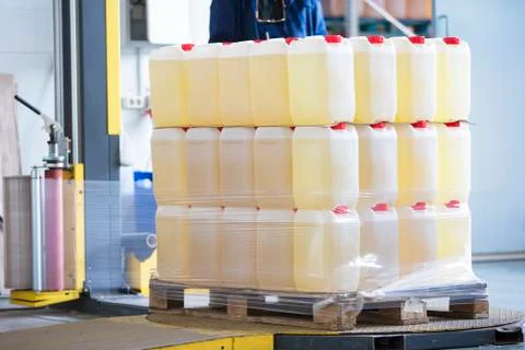 The machine for packing cellophane. Plastic jars wrapped in cellophane Stock Photos