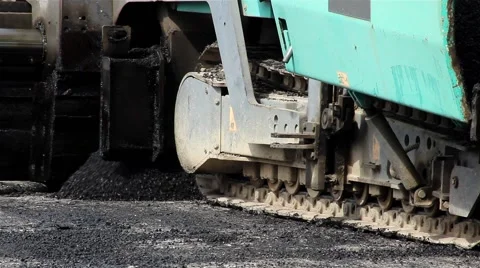 Machine for paving apply asphalt to road. Worker with shovel taking asphalt. Stock Footage 41459845