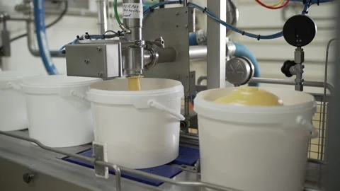 Machine pours cream into a bucket medium shot Stock-Footage 130356874