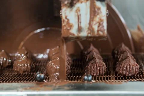 Machine pours liquid on sweets. Stock Photos