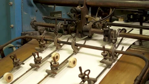 Machine in printing house folding papers with rollers on a conveyor belt Stock Footage 157713203