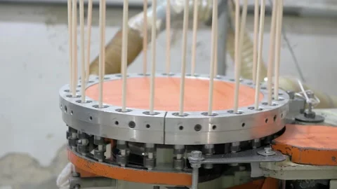 A machine processes wooden dowels, arranging them vertically Stock Footage 296247816