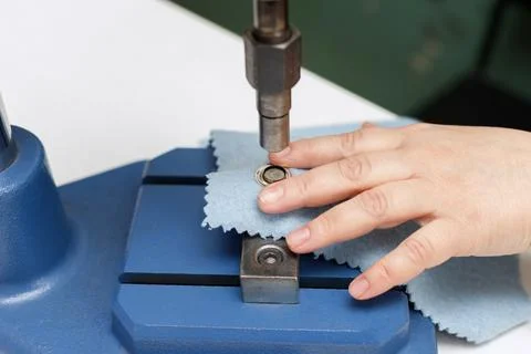 Machine puts a rivet on the fabric Stock-Fotos