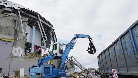 Machine puts rubbish into huge container at demolition site Stock Footage 127740347