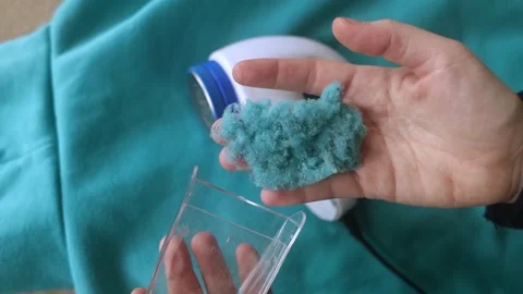 Machine for removing pellets. The girl uses a special device to remove lint from Stock Footage 228964651