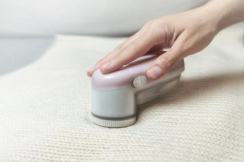 Machine for removing pellets from a woolen white jacket. 스톡 사진
