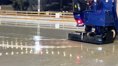 Machine for restoring ice rides on ice rink in the evening, special machine i Stock Footage 145973220