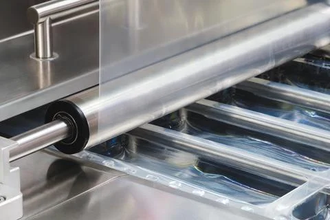 A machine with a roll of polyethylene plastic wrapping film on it. The machin Stock-Fotos