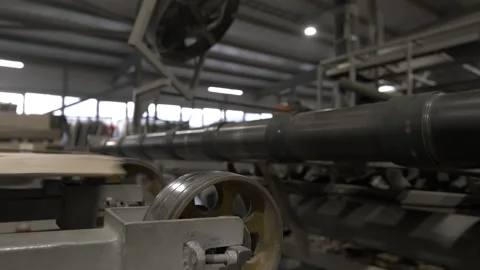 Machine rollers move flat paper sheets through spacious hall Stock Footage 296576961