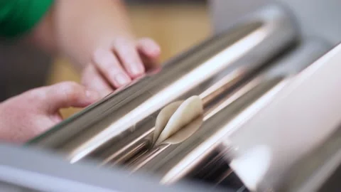 Machine rolling out and stretching homemade dough. The process of making Stock Footage 189264252