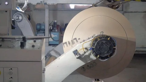 Machine rotates large roll of packaging paper in workshop Stock Footage 113398036
