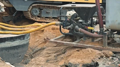A machine is seen pumping material on a construction site where gravel and sand Видео 344675979