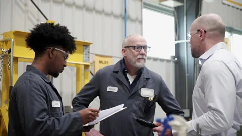 Machine shop supervisor and workers talking in meeting Stock Footage 220352423