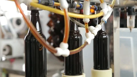 The machine substitutes the bottles under the nozzle to fill them with beer. Stock-Footage 113522939