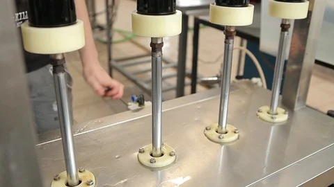 The machine substitutes the bottles under the nozzle to fill them with beer. Stock Footage 113523494