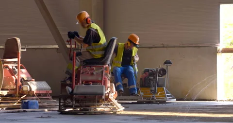 Machine trowel with an operator is used for grinding the cement surface Stock Footage 161990216