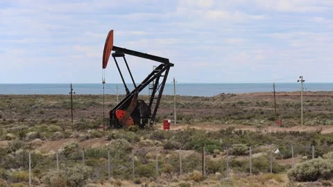 A machine used to drill for oil is operating on a Patagonian steppe Stock Footage 328168830