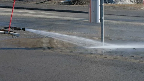 The machine is washing the street in spring after winter. Stockbeeldmateriaal 138436323