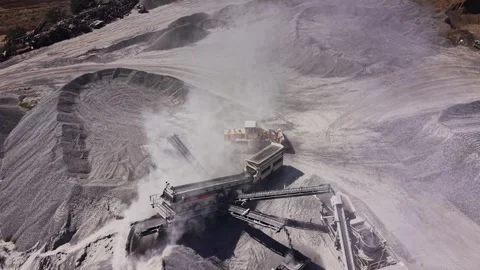 Machine working at a gravel site during the day in a dusty environment Stock Footage 344539301