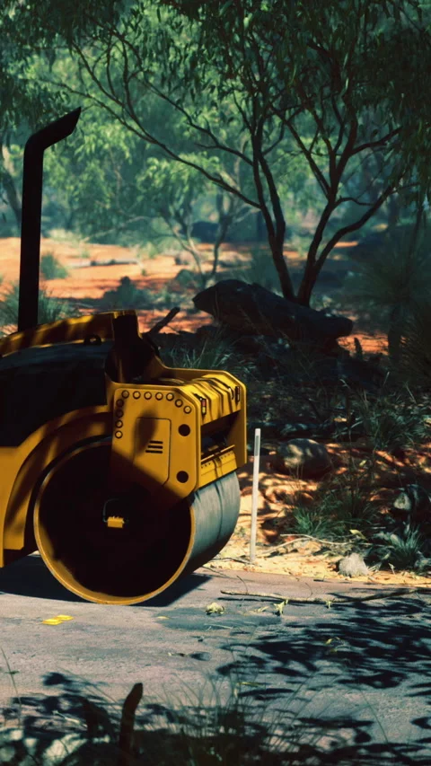 Machine works on constructing a road in the forest area near the trees Stock Footage 336029114