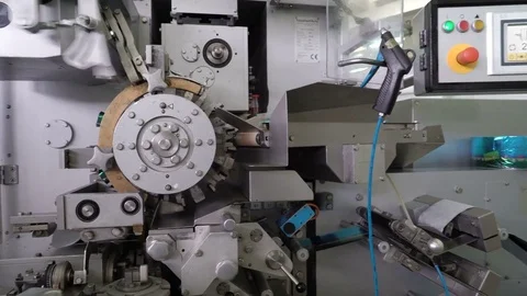 The machine wraps the candy. Confectionery factory. Sweets move along the Video stock 74187375