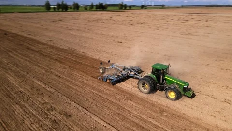 Machinery plows the field for sowing, the tractor works in the field Stock Footage 205723928