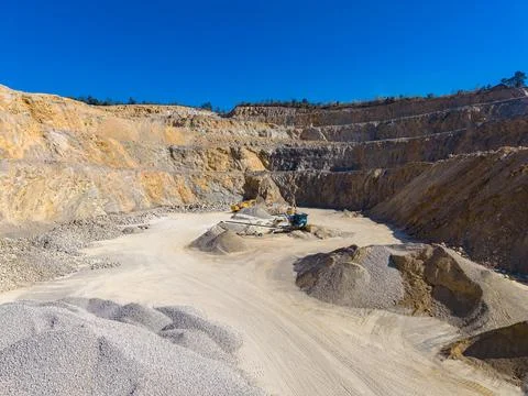 Machines extract materials in a quarry situated in a hilly area. Dust and roc Stock Photos