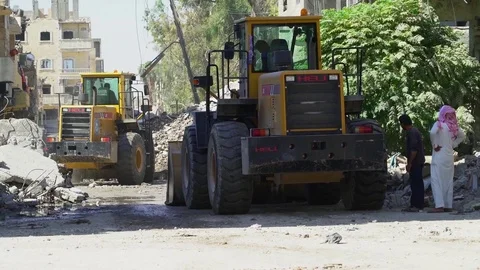 Machines work to clear rubble from streets of Raqqah, Syria Stock Footage 94565383