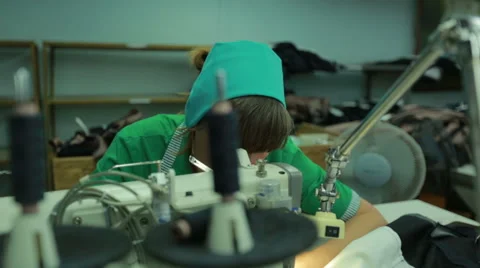 Machinist using sewing machine in clothing factory Stock Footage 62522757