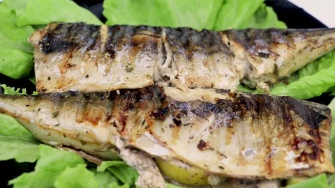 Mackerel is roasted on an electric grill. Grilled fish with lemon and salad Stock Footage 101028887