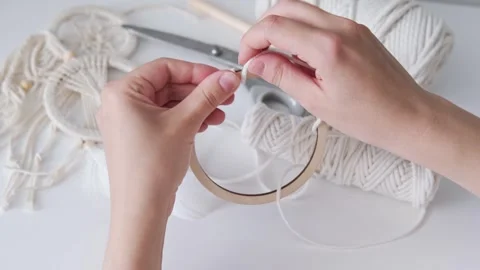 Macrame. The girl weaves macrame. White thread, female hand Stock Footage 244449530