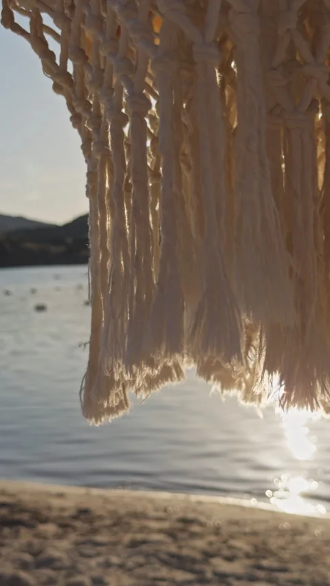 Macrame Net Pattern Backlit by Golden Sunset Light Over Calm Bay 4K Cinematic Stock Footage 338403146