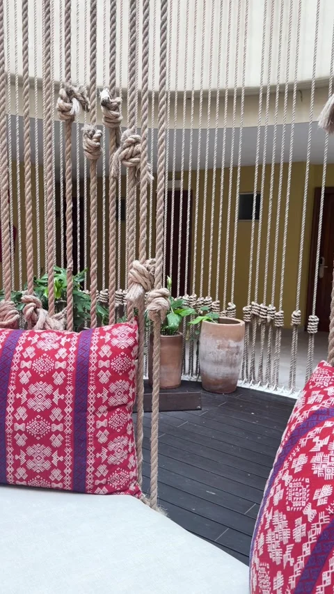 Macrame Rope Decor and Patterned Cushions in Boutique Resort Courtyard Stock Footage 342351502