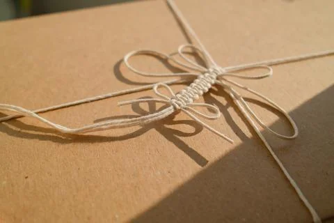 Macrame string decorates brown paper package with sunlight Stock Photos