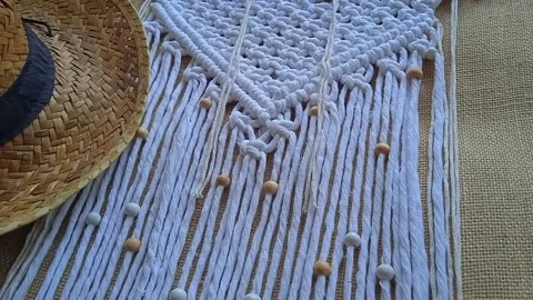 Macrame wall hanger with grain and cowboy hat, boho style. Home decor video Stock Footage 202097182