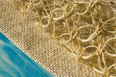 Macrame weaving from straw on a turquoise background. Stock Photos