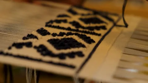 Macro 4K Lace Rug Pattern with Blurred Weaving Hands in Background Stock Footage 327863457